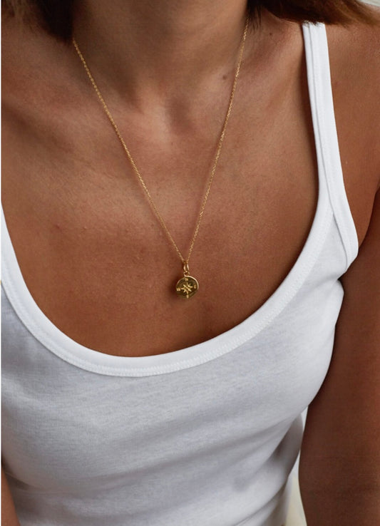 Small gold compass on trace chain